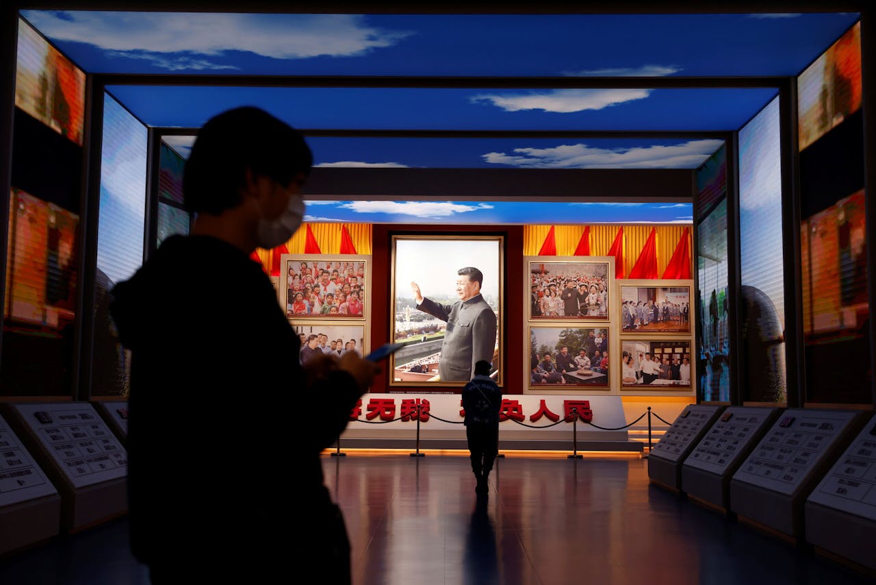 Bezoekers bij afbeeldingen van president Xi Jinping in het museum van de Communistische Partij in Peking