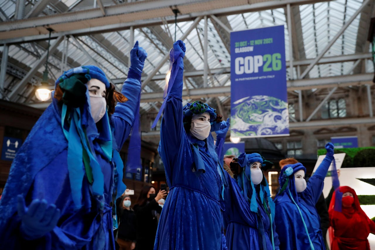 Klimaatactivisten protesteren op het centraal station van Glasgow op de eerste dag van de klimaattop.