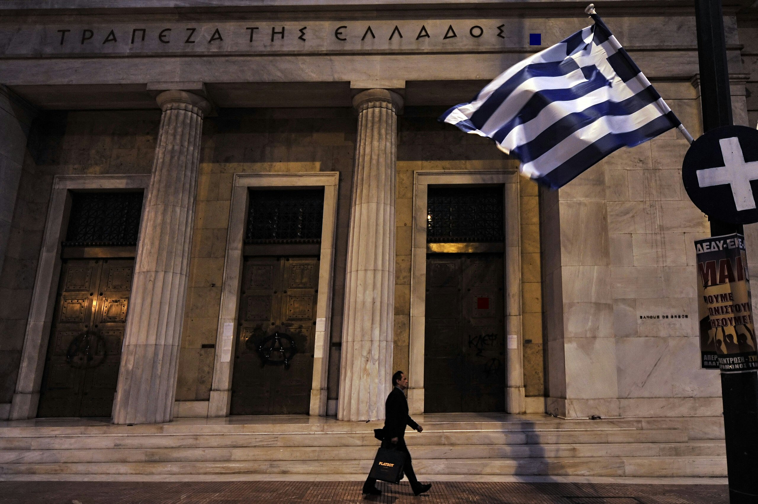 Een man loopt langst het hoofdkantoor van de Griekse centrale bank in Athene.