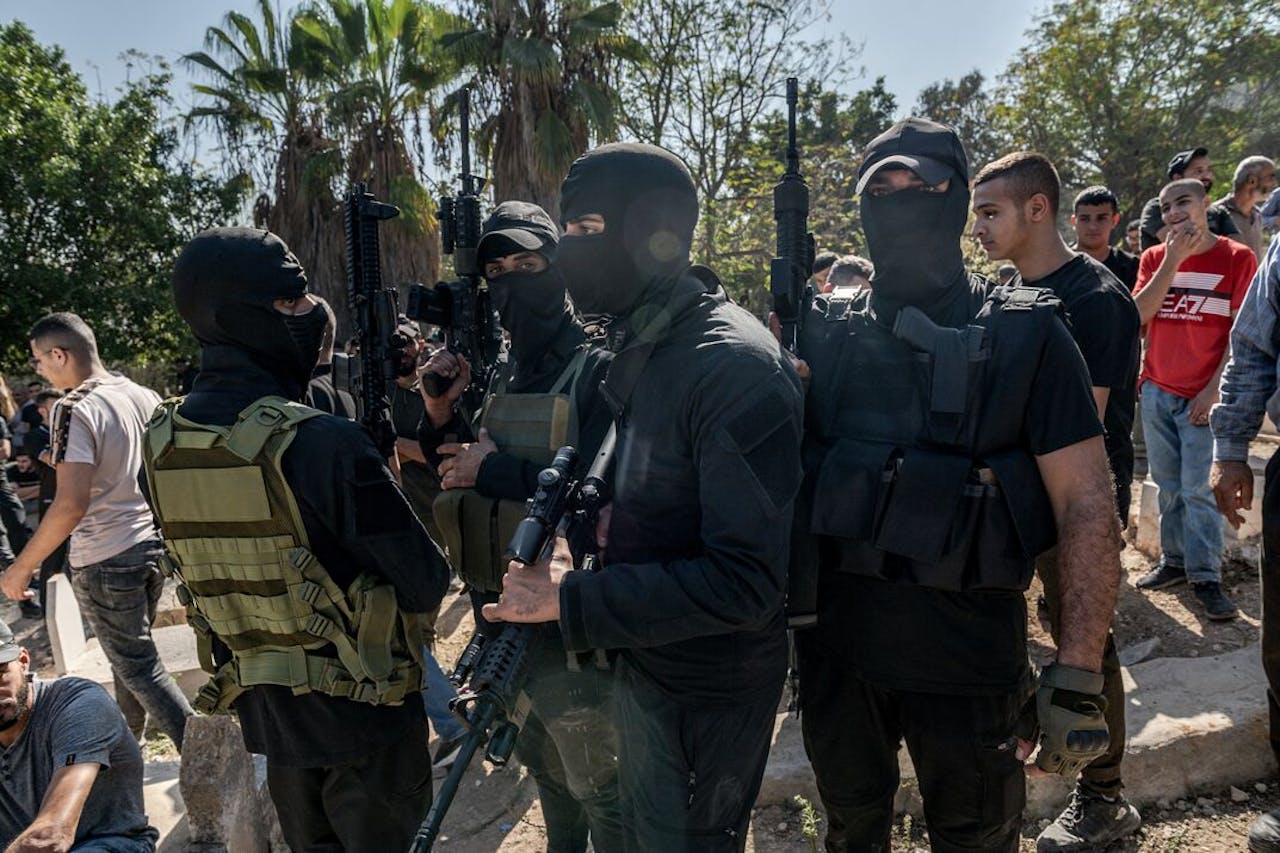 Gemaskerde militieleden van Hamas dragen hun wapens tijdens de begrafenis van vier jonge mannen die gedood werden door het Israëlische leger. Een Nederlandse stichting wordt verdacht van het financieren van de organisatie.