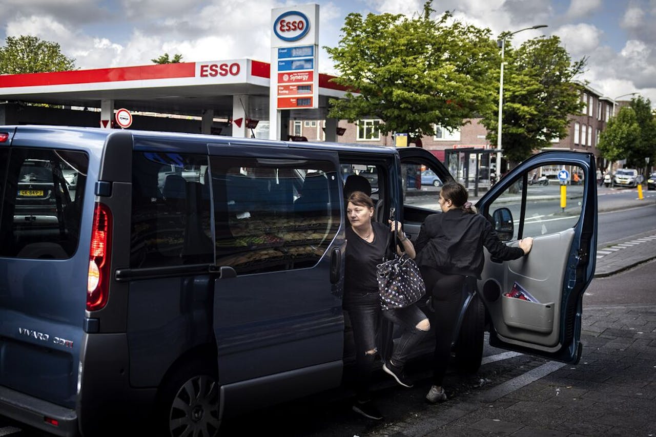 Arbeidsmigranten worden na hun werk met busjes afgezet in Den Haag.