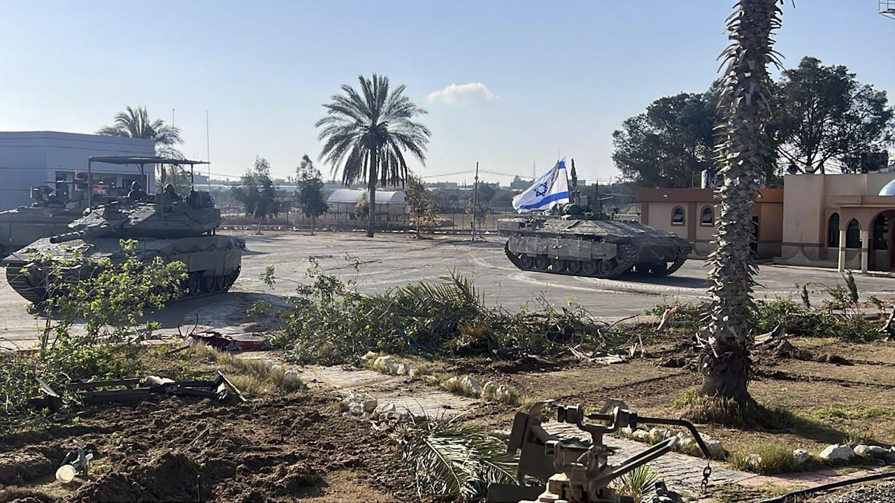 Op een foto die dinsdagochtend is vrijgegeven door de Israëlische legertop is bij de zuidelijke grensovergang een tank te zien en een pantservoertuig met een Israëlische vlag .