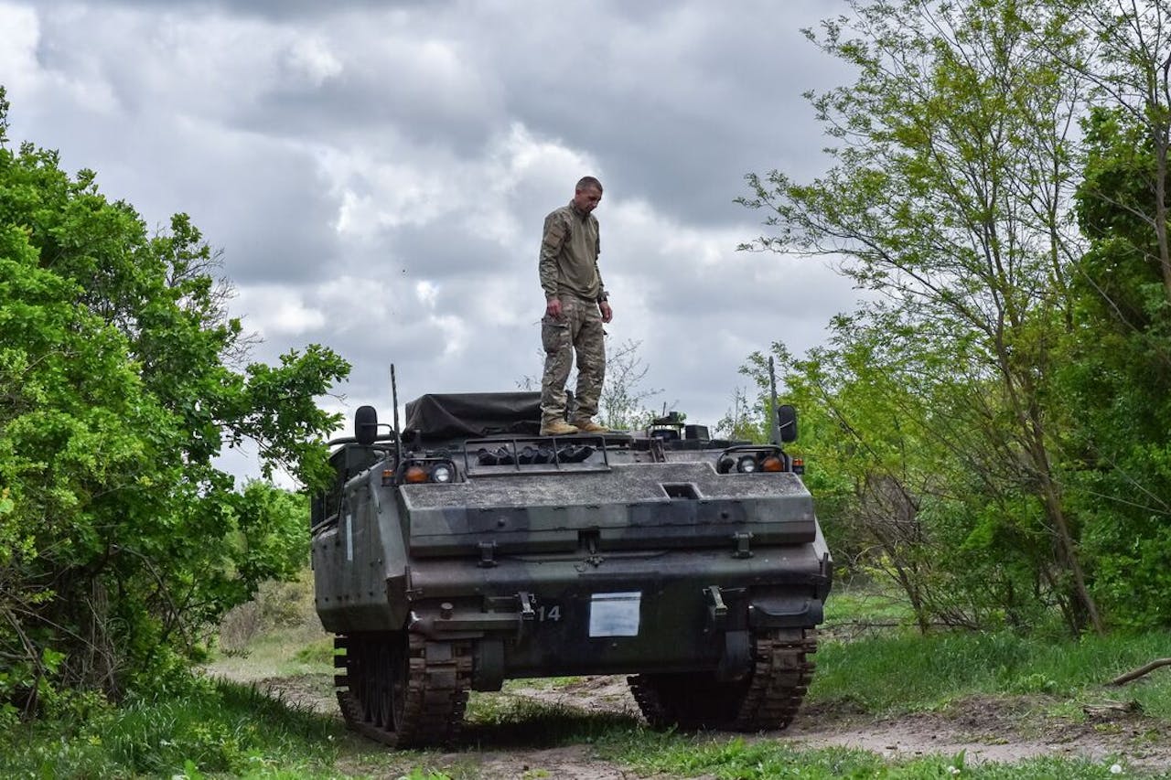Een Oekraïense soldaat op een militair voertuig.