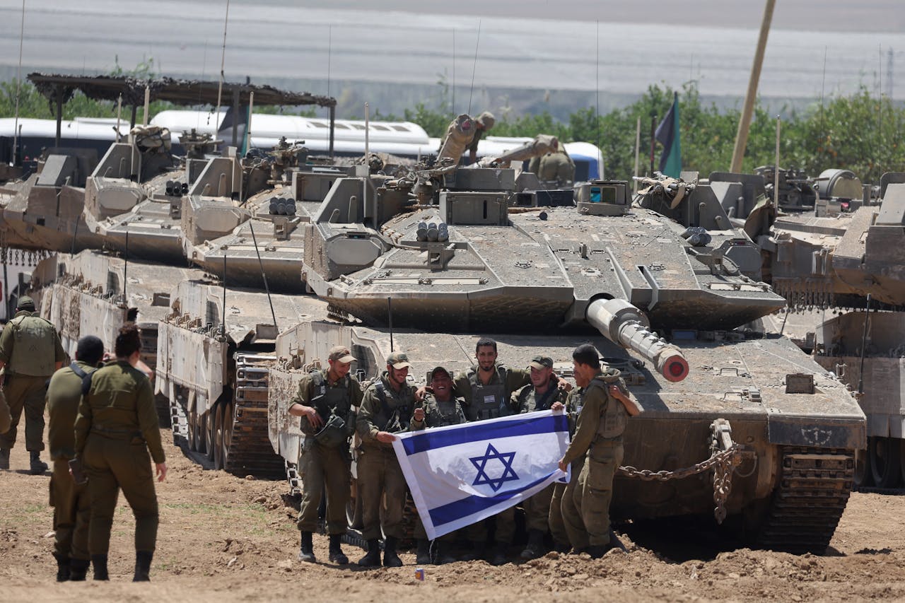Een groep Israëlische soldaten toont de vlag van het land, vlakbij de grens met de Gazastrook.