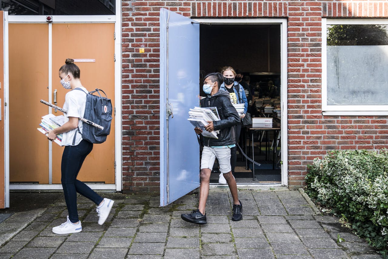 Leerlingen in Leek halen na de zomervakantie hun boeken op voor het nieuwe schooljaar. De coronaregels, zoals het 1,5 meter afstand houden tot leraren en het dragen van mondkapjes in gangen en kantines, blijven voorlopig van kracht.