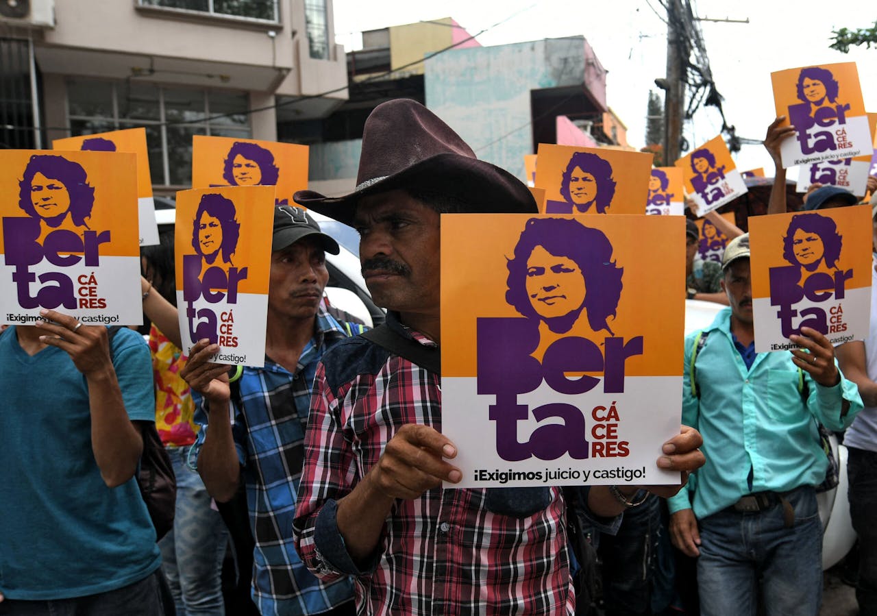 Leden van Copinh, een organisatie die opkomt voor de rechten van de oorspronkelijke bewoners van Honduras, dragen posters met daarop een afbeelding van de vermoorde activiste Berta Cáceres. Orlando Sierra/AFP