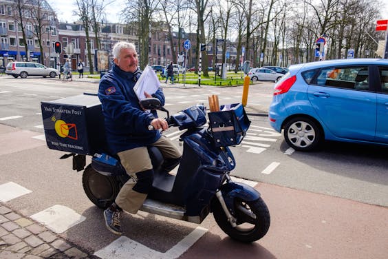 Een postbezorger op een elektrische scooter.