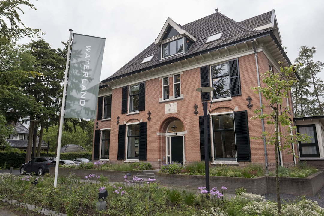 Het hoofdkantoor van Waterland is gevestigd in een statige villa in Bussum. Op de parkeerplaats veel Tesla’s.