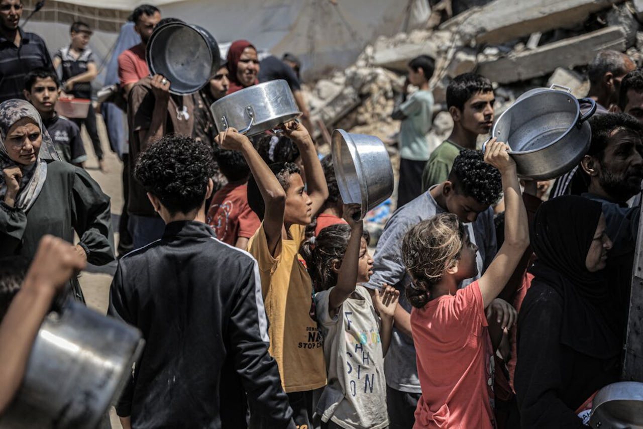 Palestijnse kinderen staan in de rij bij het uitdelen van voedsel.