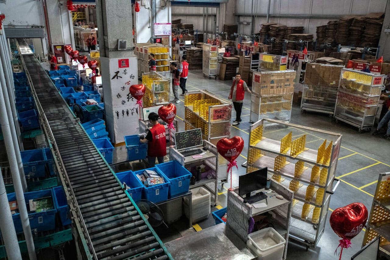 Werknemers van pakjesbezorger JD.Com in een magazijn in de Chinese stad Kuchan maken zich op voor drukke dagen wegens het koopjesfestijn 618.