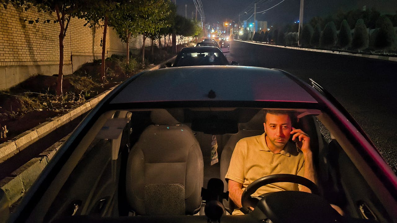 Een man in de rij voor een tankstation, een paar kilometer ten westen van Teheran.