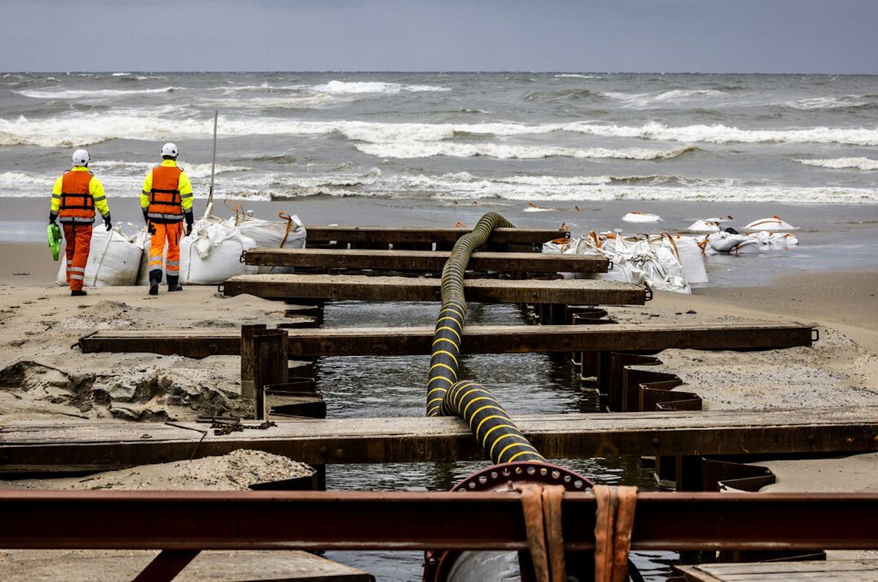 Medewerkers van een aannemer graven in opdracht van netbeheerder TenneT geulen voor de zeekabels die stroom van nieuwe windparken gaan afvoeren.