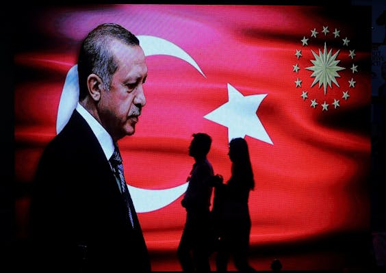 Voorbijgangers passeren in Istanboel een verkiezingsposter met daarop de beeltenis van president Erdogan.