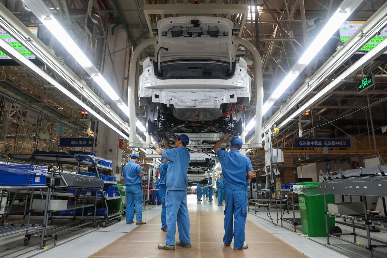 Werknemers van SAIC bij een productielijn van de Chinese autofabrikant in Shanghai. In China werkt het concern onder meer samen met Volkswagen.