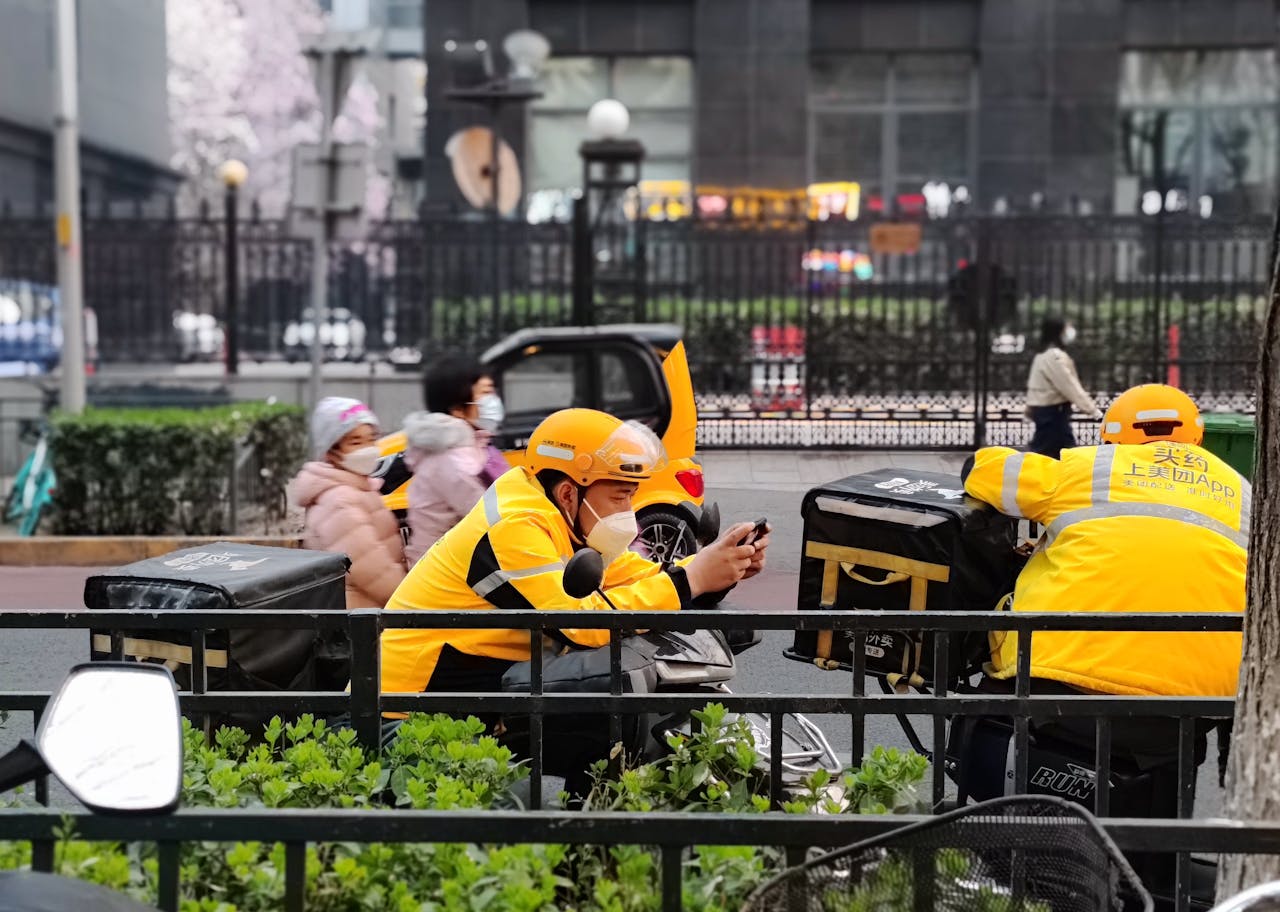 Fastfoodbezorgers wachten op klanten in het centrum van Peking.