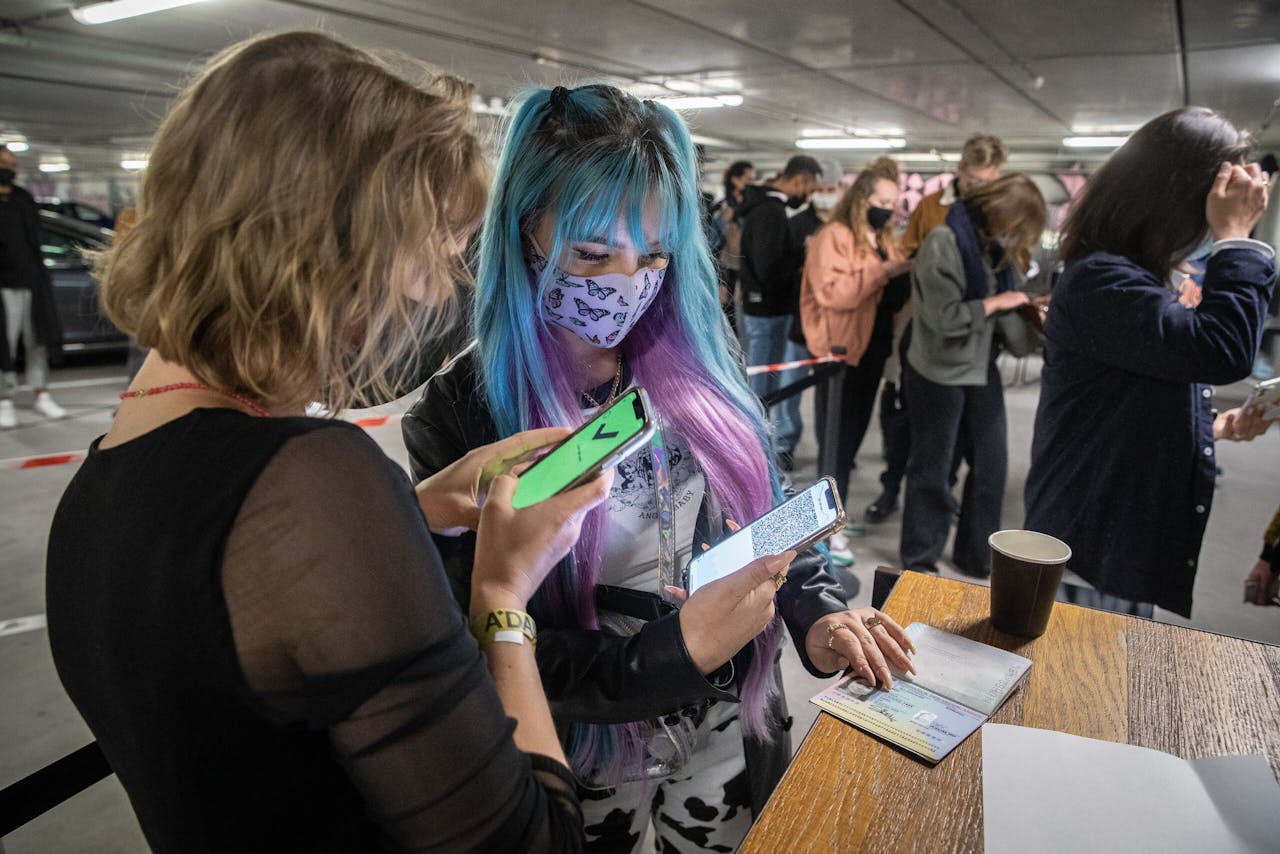Bezoekers van club Shelter in Amsterdam laten hun coronatestbewijs zien tijdens een Fieldlab-evenement.