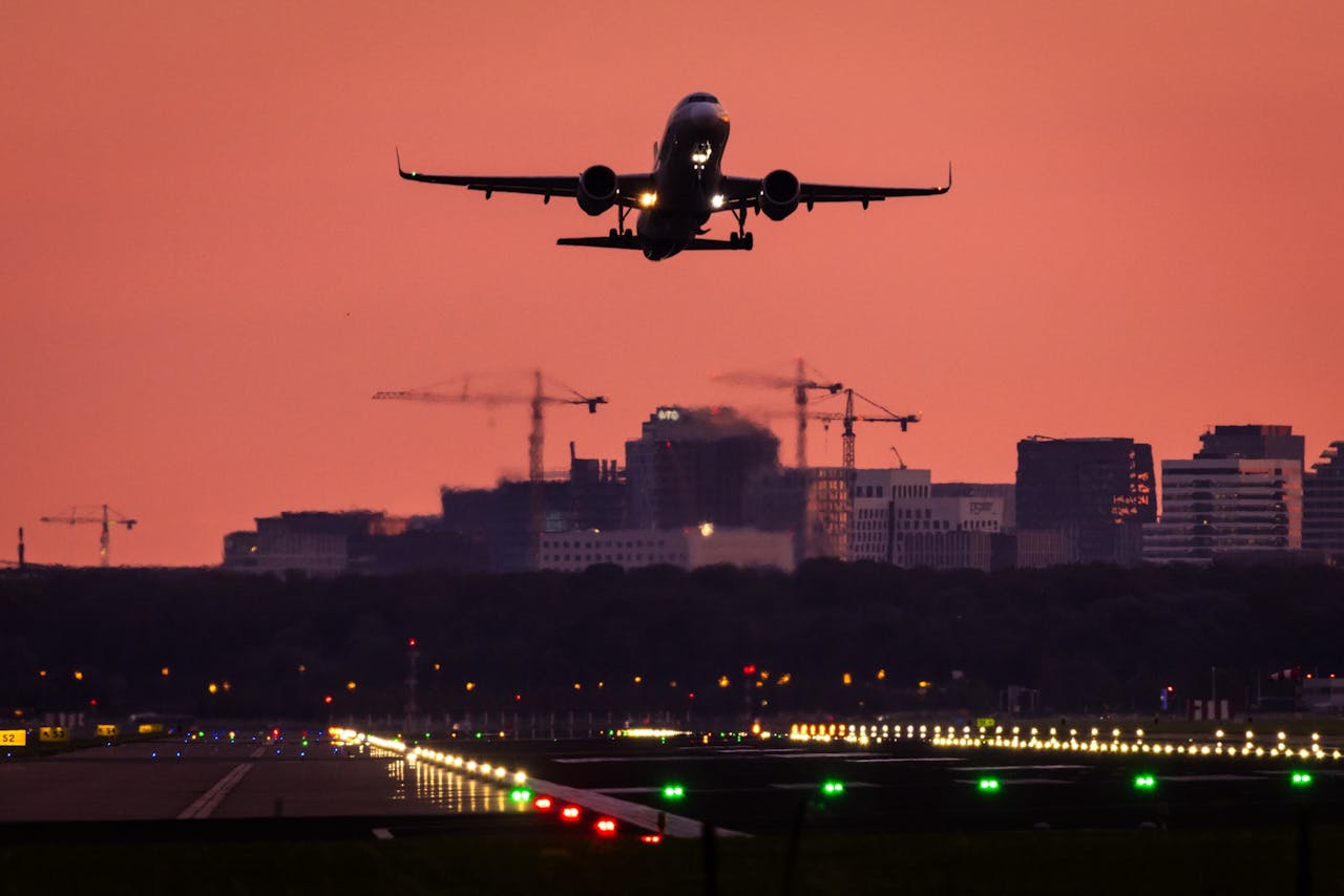 Een vliegtuig stijgt op in het ochtendlicht op luchthaven Schiphol.