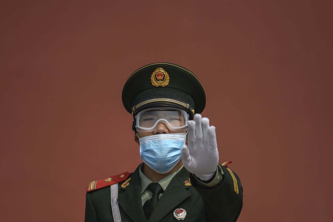 Een politieagent met mondmasker bij de Verboden Stad in Peking.