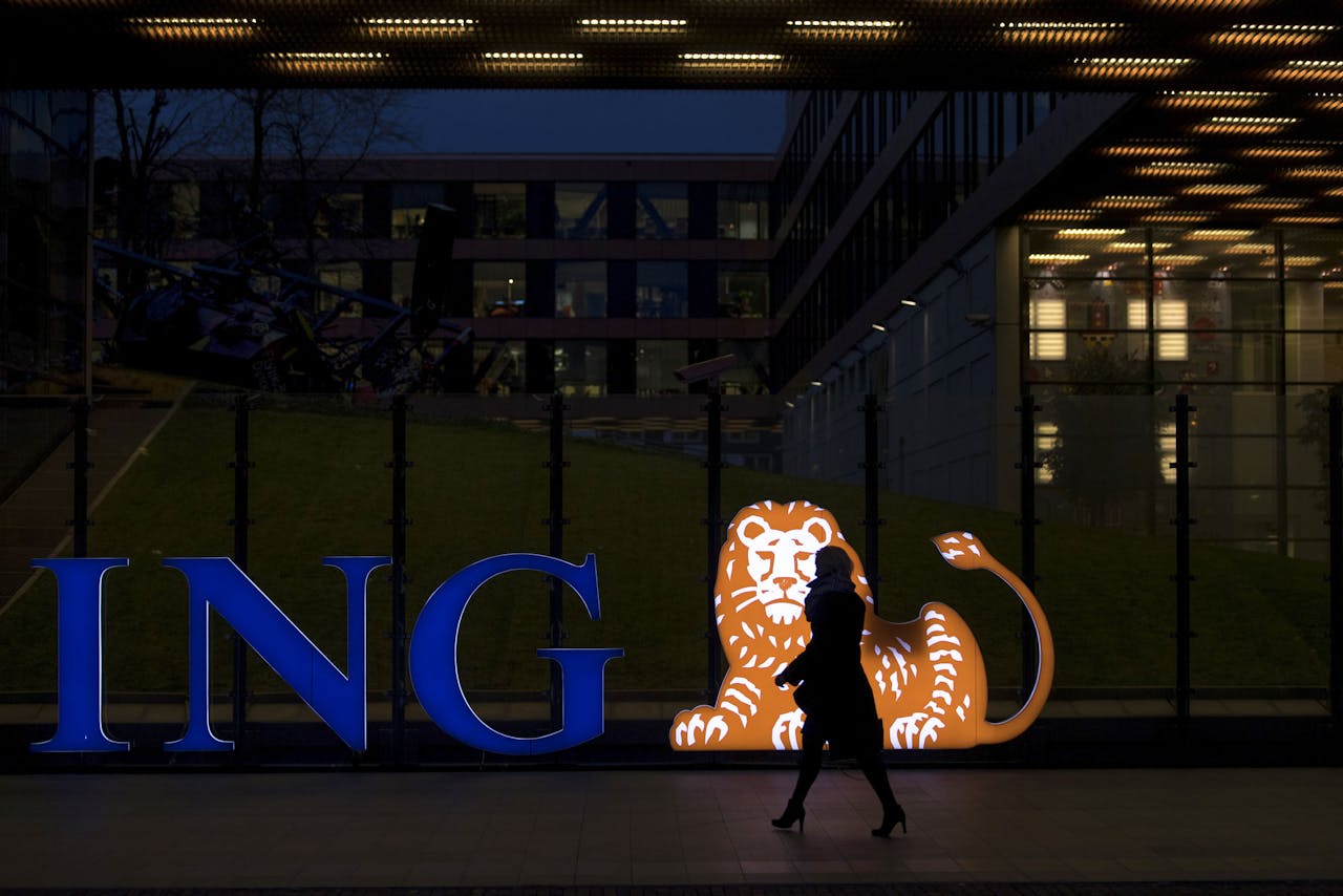 Een bezoeker van een ING-kantoor loopt langs het verlichte logo.
