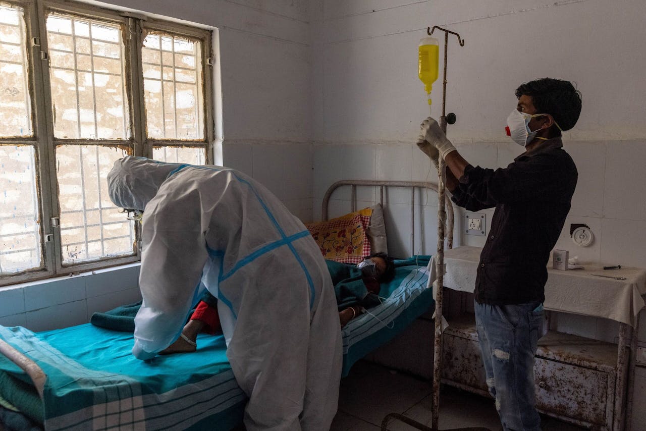 Devi wordt behandeld door de enige arts in de geïmproviseerde coronakliniek in haar dorp. De kliniek beschikt nauwelijks over apparatuur en geregeld valt de stroom uit.