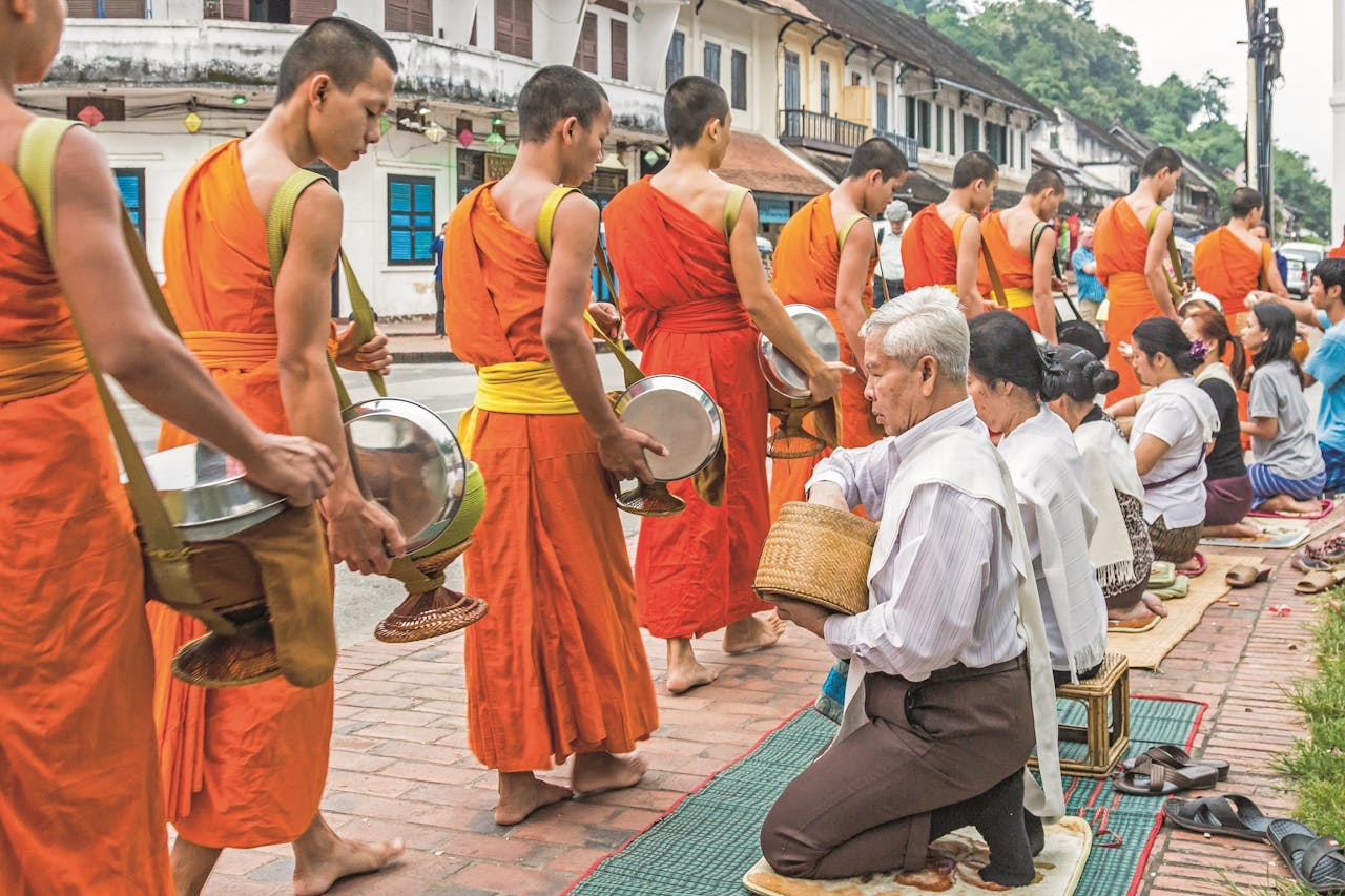 De bewoners van Laos delen eten uit aan monniken, als offer.