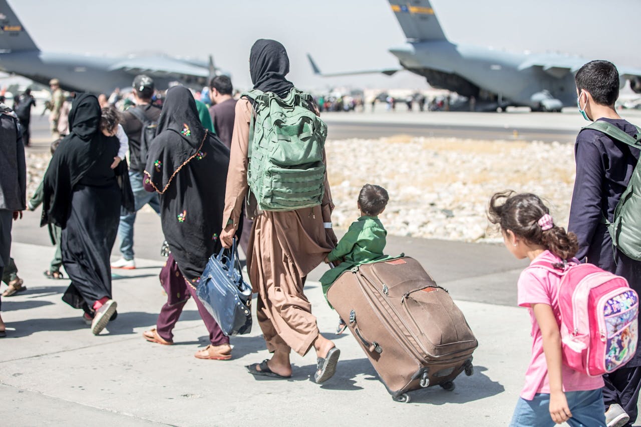 Evacuatie van Afghanen op het vliegveld van Kaboel. De Wereldbank heeft nu ook uitbetalingen aan Afghanistan stopgezet, waardoor het nieuwe regime steeds meer verlegen zit om geld.