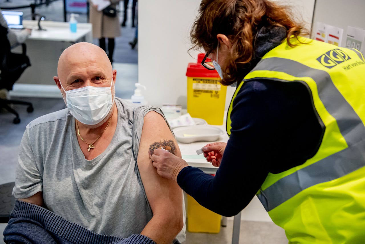Een zorgmedewerker laat zich vaccineren tegen het coronavirus in de GGD-priklocatie.
