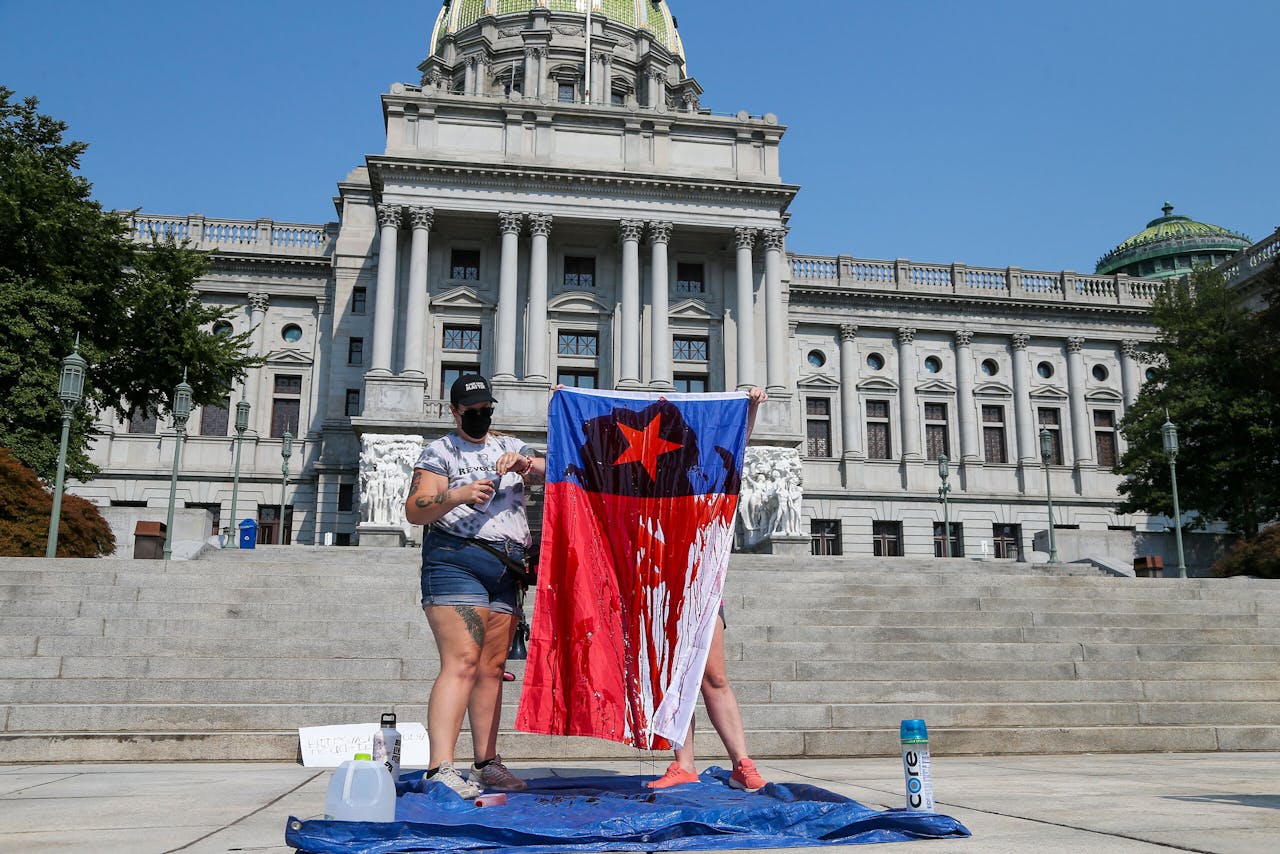 Demonstranten houden een 'bebloede' vlag op tijdens een pro-lifeprotest voor het parlementsgebouw in Pennsylvania.