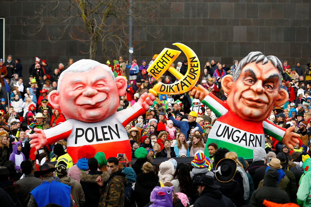 Carnavalsgangers lopen bij het carnaval van 2018 in Düsseldorf met poppen van Jaroslaw Kaczynski (l), de leider van de Poolse regeringspartij PiS, en de Hongaarse premier Viktor Orbán.