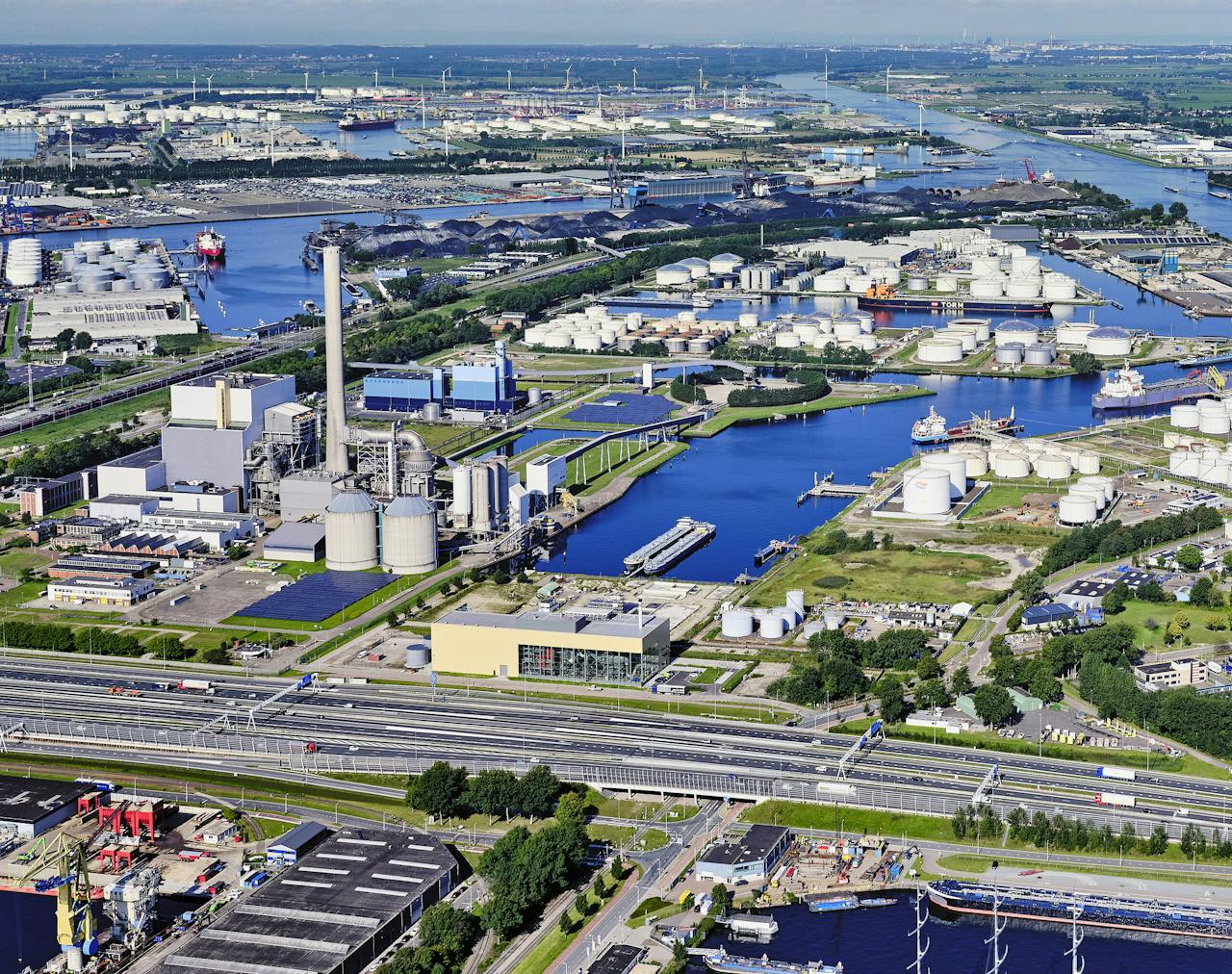 Het Westelijk Havengebied van Amsterdam. De geelkleurige biomassacentrale van AEB, langs de ringweg A10, werd deze zomer in gebruik genomen, maar al tijdens de opstartfase bleek de milieuvergunning ondeugdelijk.