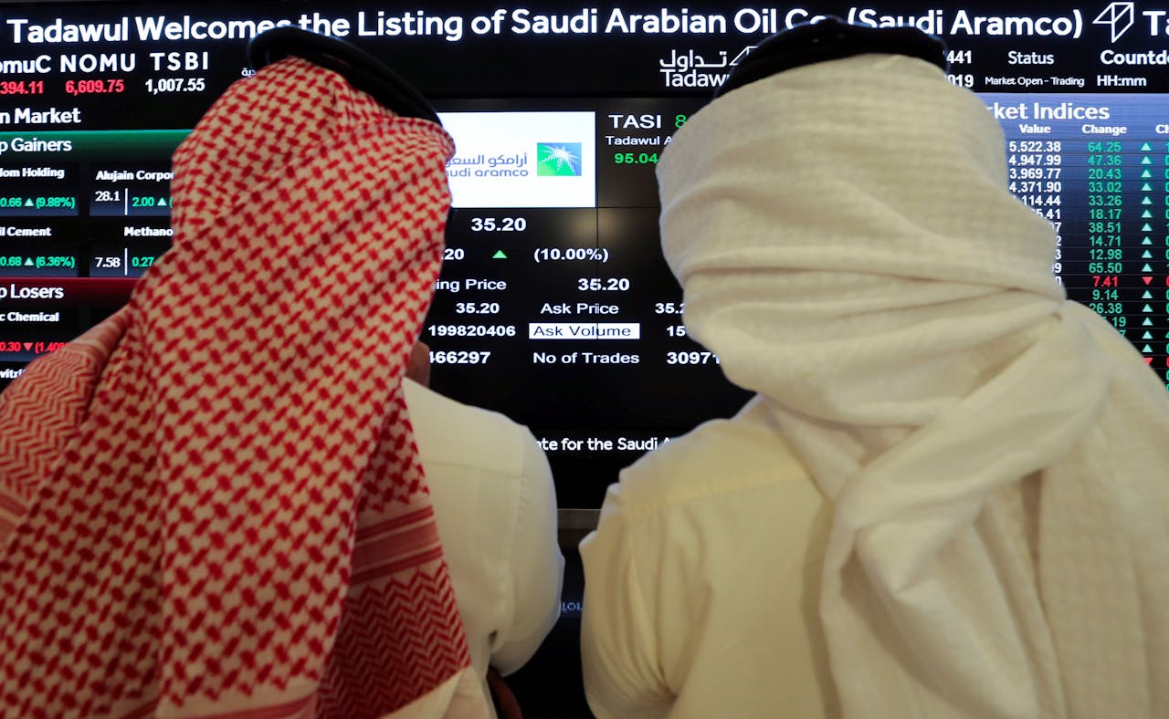 Beleggers volgen de koers van Aramco op de Saudi Stock Exchange (Tadawul) na het debuut op de beurs in Riyad.