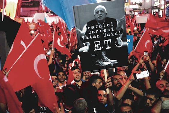 Demonstranten houden een bord omhoog met het portret van geestelijk leider Fethullah ‘Feto’ Gülen.