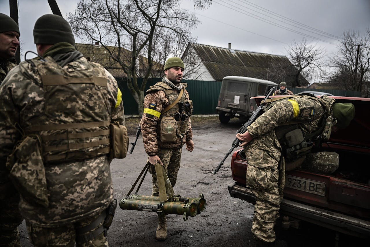 Oekraïense soldaten halen wapens uit een oude auto, vlakbij Kiev.