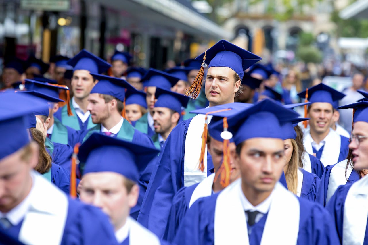 Afstudeerders van de Rotterdam School of Management lopen door de Rotterdamse binnenstad.