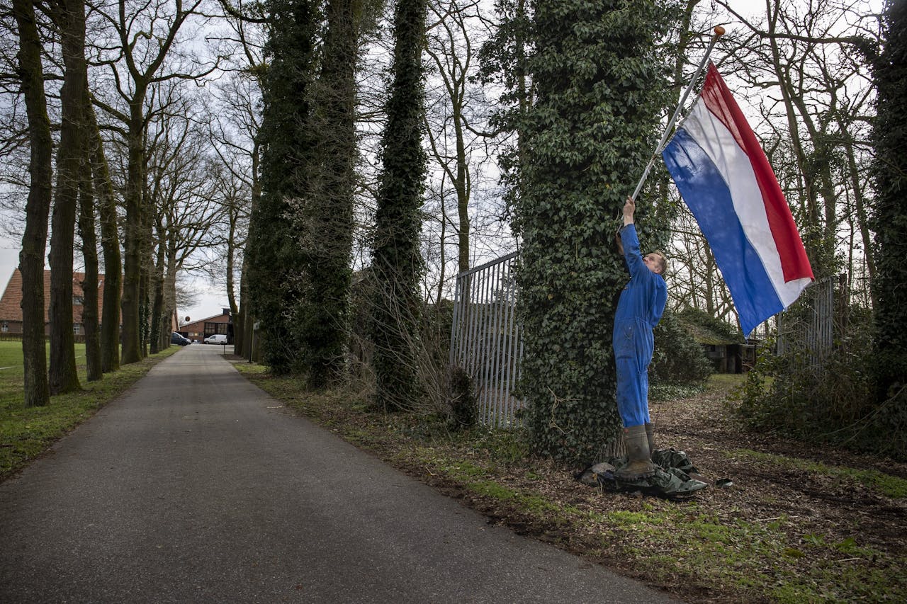 Melkveehouder Walter Luttikhuis draait na de winst van BoerBurgerBeweging (BBB) de Nederlandse vlag weer om met het rood boven bij zijn melkveehouderij in het landelijke buitengebied van Tubbergen.