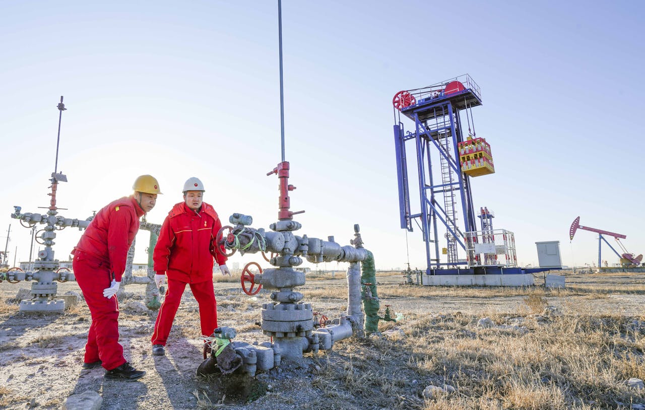 Werknemers inspecteren een oliebron op het Jidong olieveld in Noord-China.