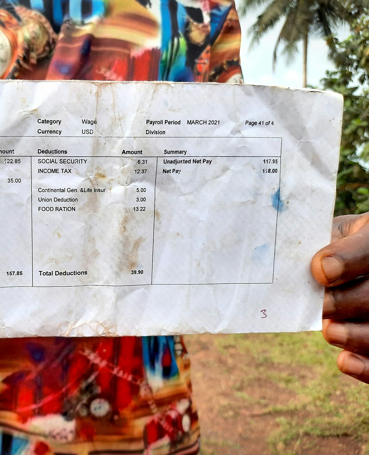 Een werknemer van MOPP laat een salarisstrookje zien. Het salaris van MOPP ligt boven het minimumloon in Liberia, maar de arbeiders klagen over de arbeidsomstandigheden.