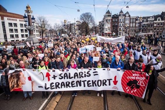 Duizenden basisschoolleerkrachten uit Amsterdam komen in maart bijeen om te demonstreren voor salarisverhoging. In het midden Thijs Roovers, links van hem Jan van de Ven.