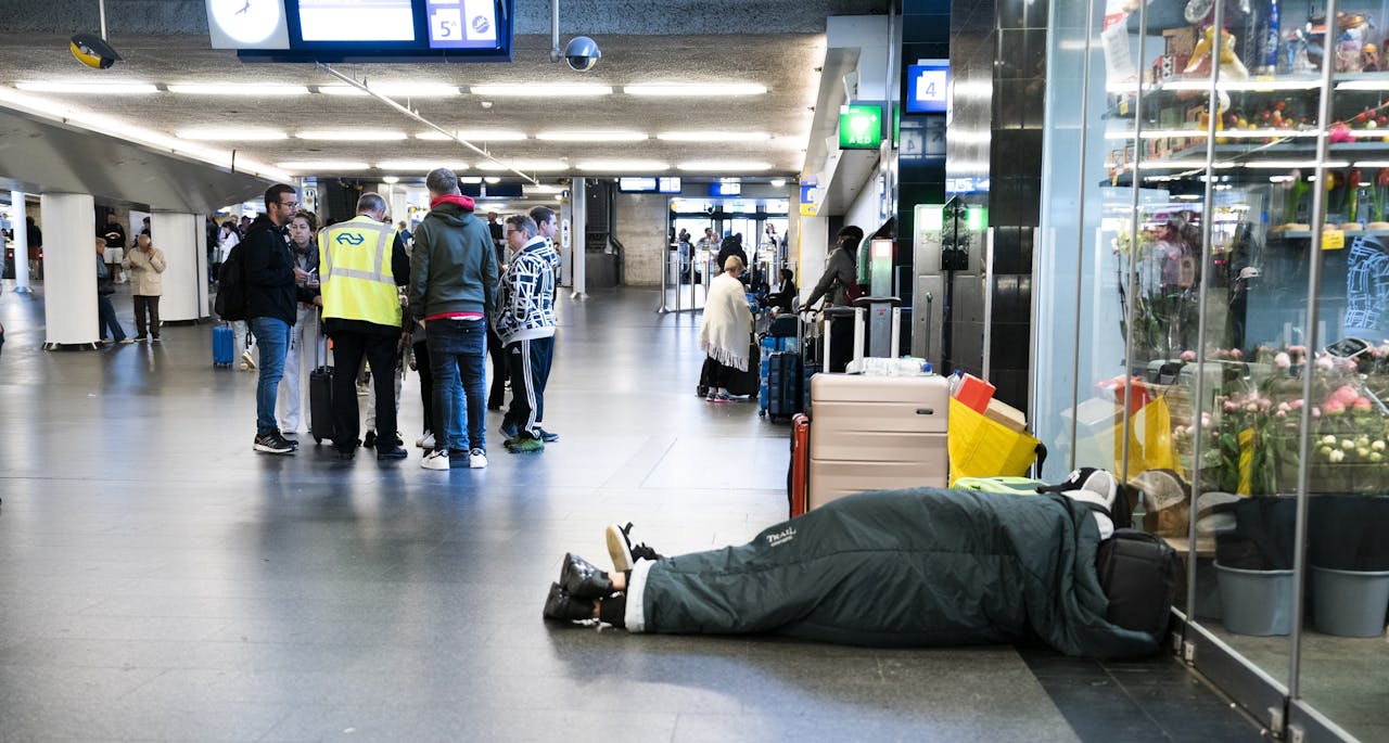 Reizigers wachten zondagavond tevergeefs op een trein op station Amsterdam Centraal.