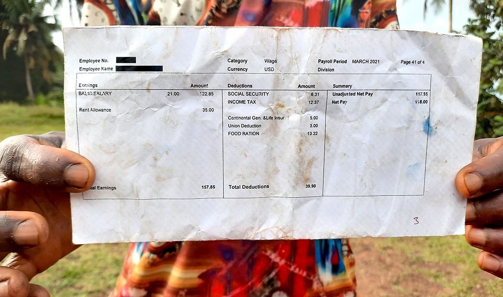 Een werknemer van MOPP laat een salarisstrookje zien. Het salaris van MOPP ligt boven het minimumloon in Liberia, maar de arbeiders klagen over de arbeidsomstandigheden.