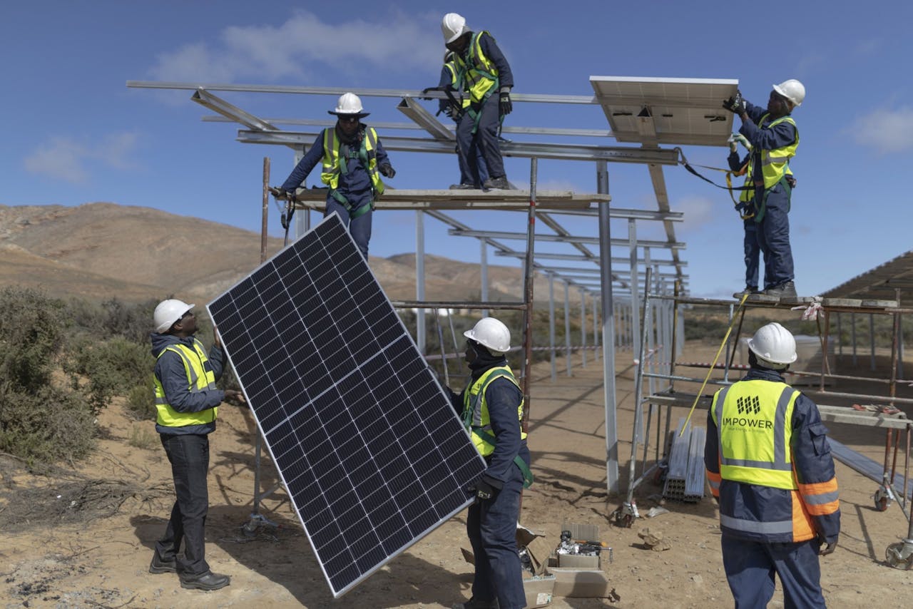 Zuid-Afrikaanse monteurs installeren zonnepanelen. Voor het maken van groene waterstof is zonne- en windenergie nodig.