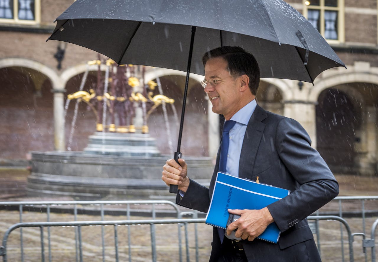 Demissionair premier Mark Rutte snelt door de regen naar zijn afspraak met informateur Mariëtte Hamer.