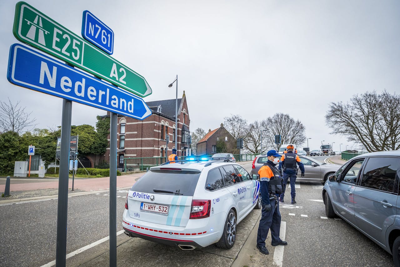 Vlaamse politieagenten bij de Belgische grens met Nederland. De Belgen hebben de grenzen gesloten voor 'niet-essentiële verplaatsingen'. De maatregel is bedoeld om de verspreiding van het coronavirus aan banden te leggen.