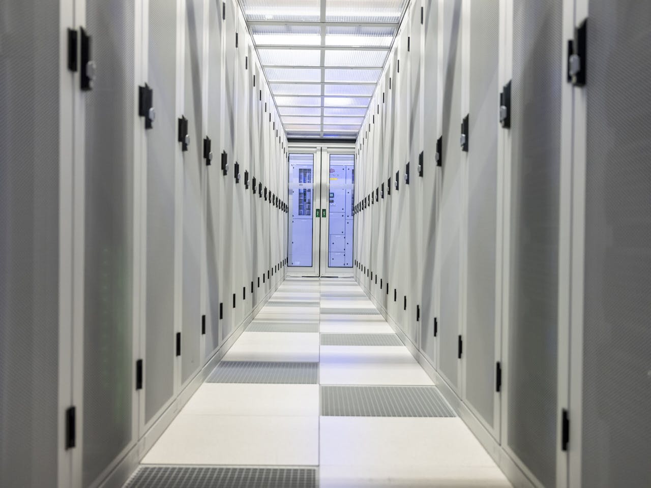 Gang met servers. Via openingen in de vloer wordt koude lucht de gang ingeblazen om de servers te koelen.