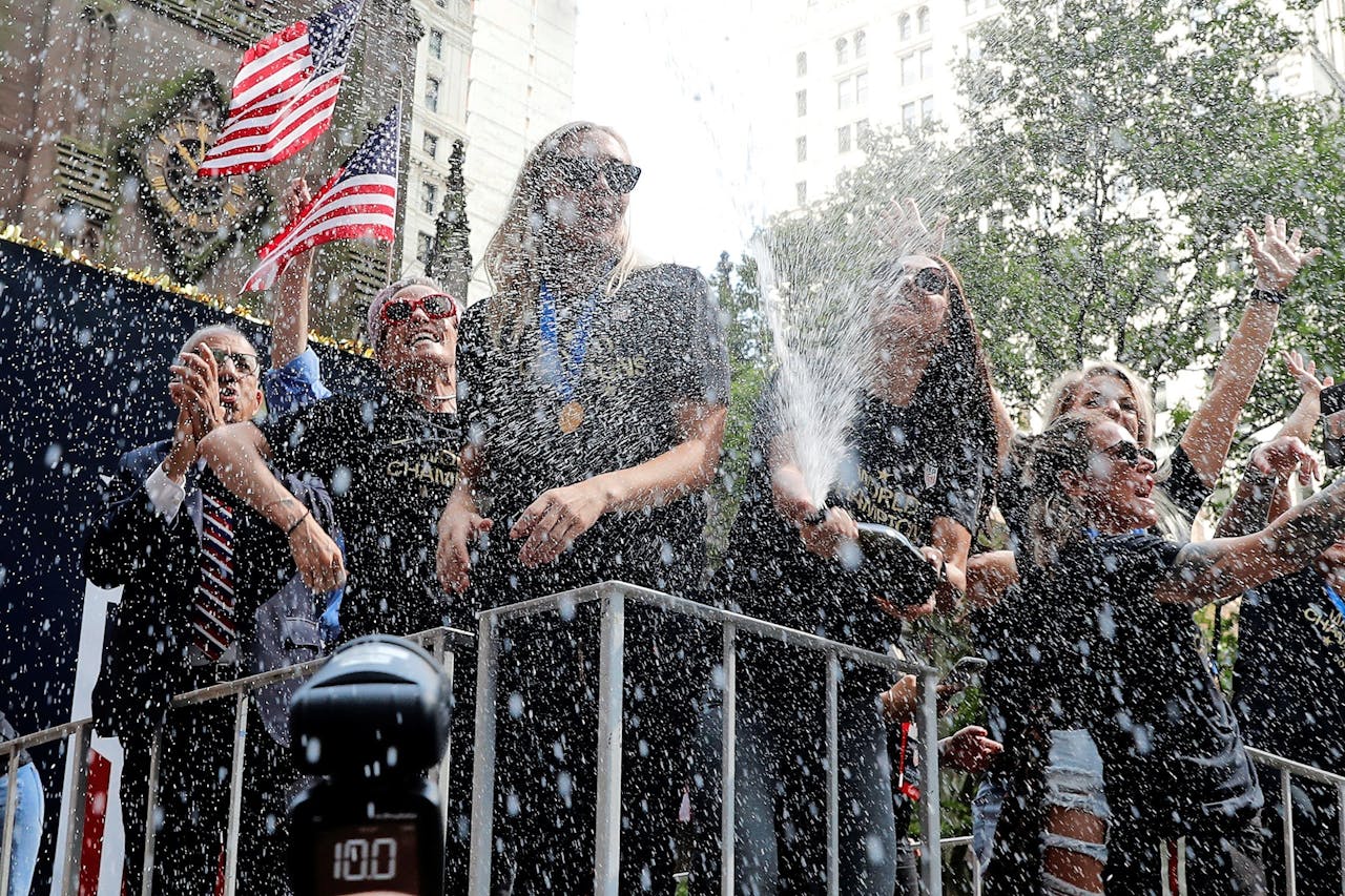 De Amerikaanse voetballer Alex Morgan spuit champagne tijdens een optocht in New York.