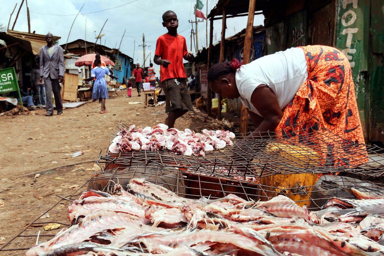 Een marktkoopvrouw verkoopt bij een viskraam in de Keniaanse hoofdstad Nairobi visafval van restaurants aan inwoners van de sloppenwijk Kibera.