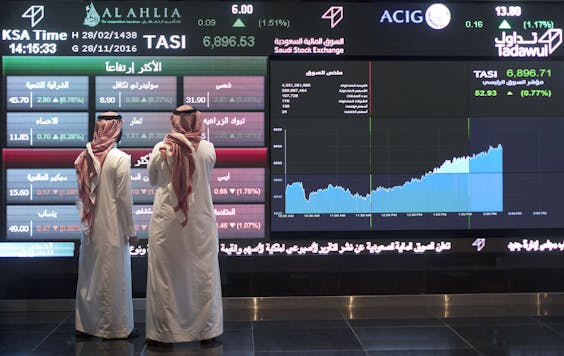 Visitors bekijken op grote schermen de koersbewegingen op de aandelenbeurs van Saoedi-Arabië.