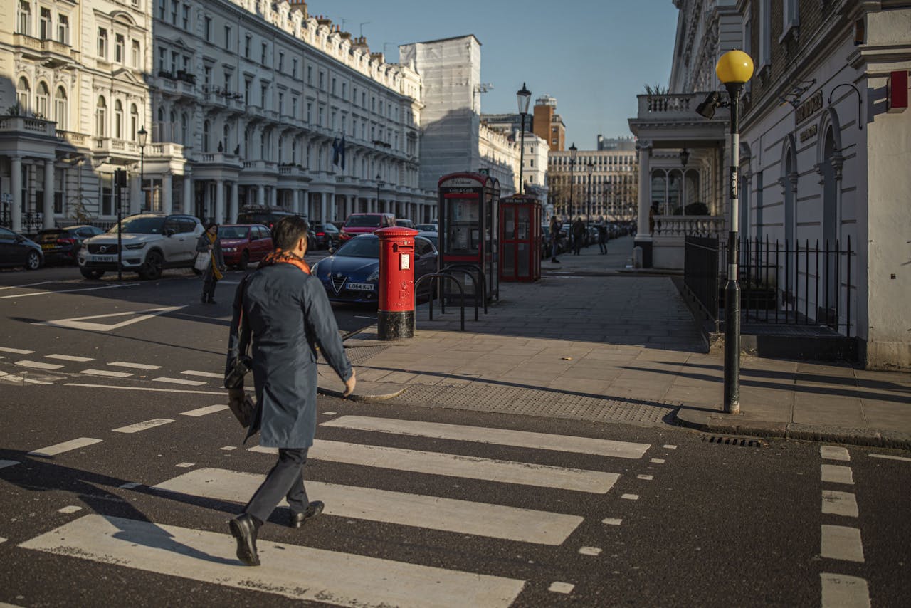 Een man steekt de straat over in de Londense wijk Kensington.