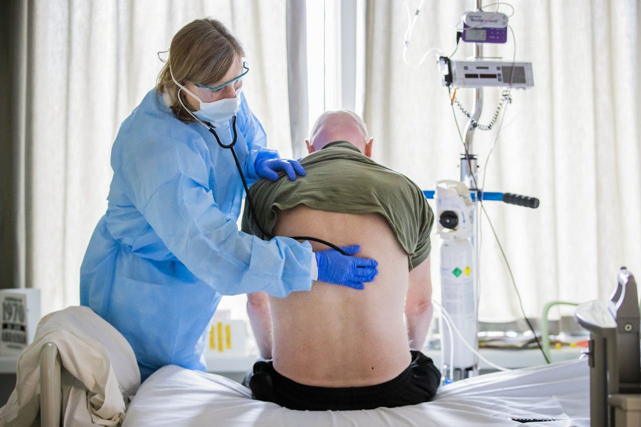 Een arts luistert naar de longen van een coronapatient op de verpleegafdeling voor coronapatienten van het HMC Westeinde ziekenhuis in Den Haag.