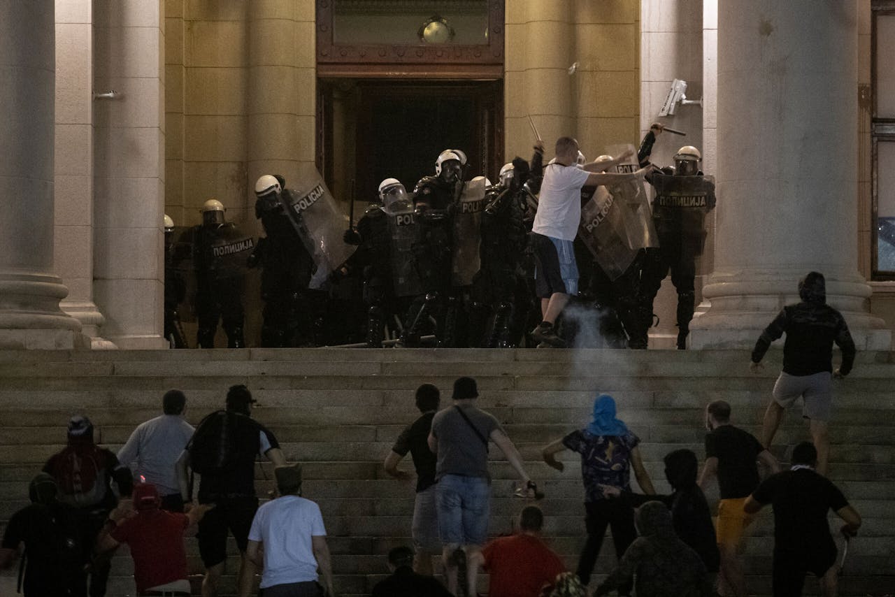 Betogers rennen de trappen van het parlement in Belgrado op bij protesten tegen de regering in juli.